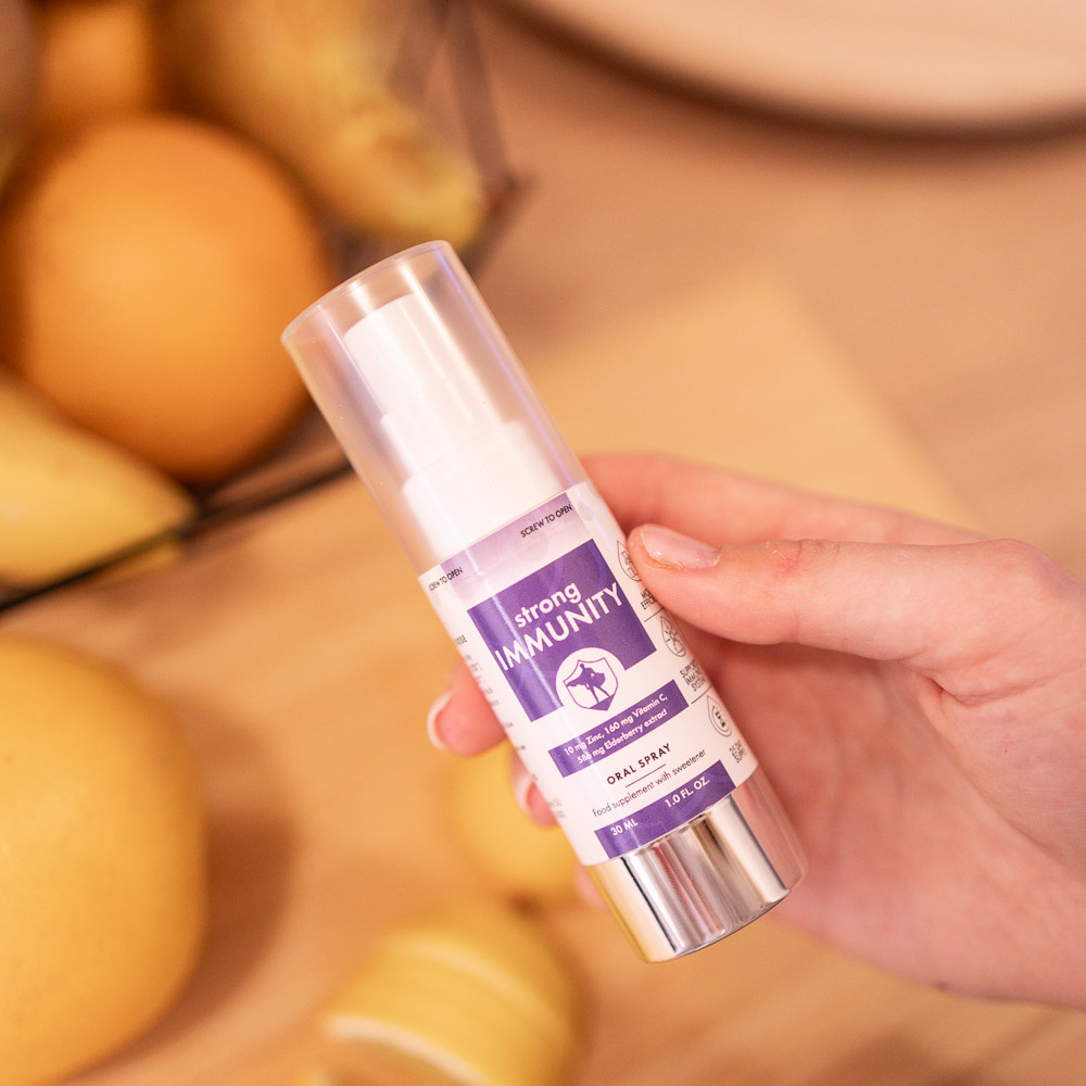 NorVita Tugev Immuunsus spreivitamiin naise käes apelsinid taustal