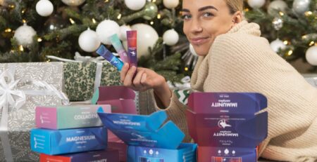 Naine jõulukuuse all NorVita vitamiinidega magneesium, mere kollageen, immuunsus