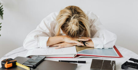 Naine on väsinud ja toetab pea lauale